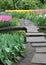 Garden stepping stone path through colorful flowers