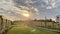 Garden during summer sunset, sprinkling water on perfect green lawn, grass, bowling green