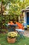 Garden table and chairs with apples and pumpkins on autumn yard. Beautiful porch home with autumn decorations on thanksgiving. Ter