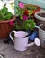 Garden table with flowerpots, watering can and working shovel outside