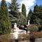 Garden of tall coniferous trees with sculpture