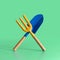 Garden tool. Blue blade and a yellow fork on green background