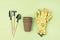 Garden Tools on Green Background Small Pots Yellow Garden Gloves Shovel Rake Horizontal Top View Gardening Spring Concept