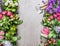 Garden tools and pink work gloves with colorful summer flowers on gray stone concrete background