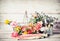 Garden tools with watering can, basket and flowers on gardening table at wooden background