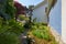 Garden and villa with stone tiled path and plants in a sunny day, Italy