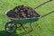 Garden-wheelbarrow filled with soil on a farm.