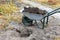 Garden wheelbarrow with soil and peat for planting roses bush used on a personal plot