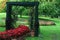 A garden with a wooden arch and flowers next to the clay pots