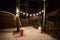 Garden with a wooden gazebo with lights, candles at night at a wedding.