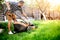 Garden worker starting the lawnmower and cutting grass in garden