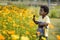 In the garden, a young African boy can be seen joyfully playing with a watering device.