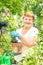 Gardener active senior elderly woman is planting flowers in pot