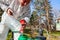 Gardener is blending substance with water in proper scale for sprinkles fruit trees