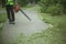 The gardener cleans up the park path. Leaf blower.