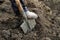 Gardener digs the soil with a steel gardening shovel with a wooden handle stuck