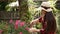 Gardener girl trimming flowers with secateurs