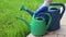 The gardener in gloves chooses a watering can for watering plants and gardening