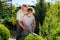 Gardener grandpa teaches granddaughter to cut the bushes gardening shears