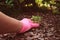 Gardener hand in pink glove removing weeds