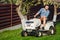 gardener and lawn mower cuts the grass using tractor