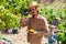 Gardener measuring sugar content of mangoes in orchard