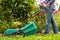 Gardener Mow Grass With Lawn Mower In Garden.