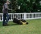 Gardener mowing the lawn with an electric mower