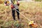 Gardener mowing weeds with brush cutter. Worker trimming dry grass with manual gasoline trimmer with metal blade disk