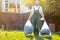 The gardener removes the bags of compost. Light. Green uniform