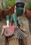 A gardener`s tools on a table with plants in background.