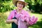 Gardener smiling while holding basket of roses.