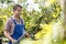 Gardener trimming tree branches at plant nursery