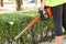 Gardener trims a bush with a brush cutter