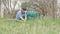 Gardener woman cleaning dry grass while gardening work in garden backyard