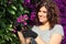 Gardener woman cutting a pink flower with secateurs