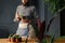 Gardener in work suit holding a cactus at table with succulents