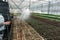 Gardener worker watering seeding plants in modern glasshouse