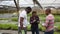 Gardeners breezily chatting in greenhouse