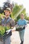 Gardeners carrying flower pots in crates at plant nursery