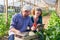 Gardeners discussing over bell pepper and tablet computer