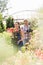 Gardeners holding potted plants outside greenhouse