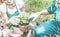 Gardeners team putting plants inside pots - Happy young people at work in community greenhouse garden - Green lifestyle and