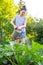 Gardening agriculture concept. Woman gardener farm worker holding watering can and watering irrigating plant. Girl