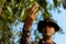 Gardening concept a male gardener looking at a fruit checking size, color, and quality before harvest season