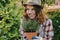 Gardening concept. Young woman holds potted lavender plant outdoors.