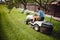 Gardening details with male worker using lawn tractor