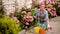 Gardening. Girl is working in garden of bushes hydrangea. Woman gardener waters flowers with watering can. Flowers are