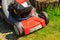 Gardening. Mowing green lawn with red lawnmower