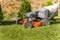 Gardening. Mowing a lawn with a gasoline lawnmower, close-up on a wheel. Grass cutting. Petrol engine